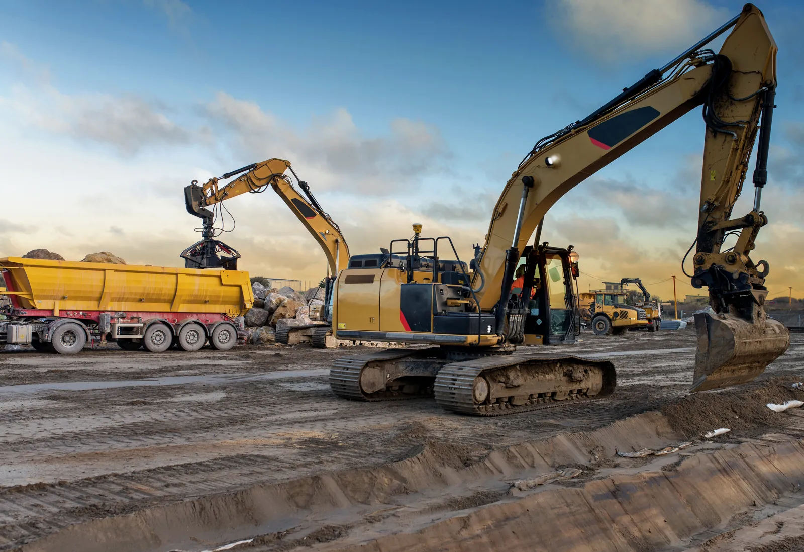 Bagger und Lkw im Einsatz auf einer Baustelle am Morgen
